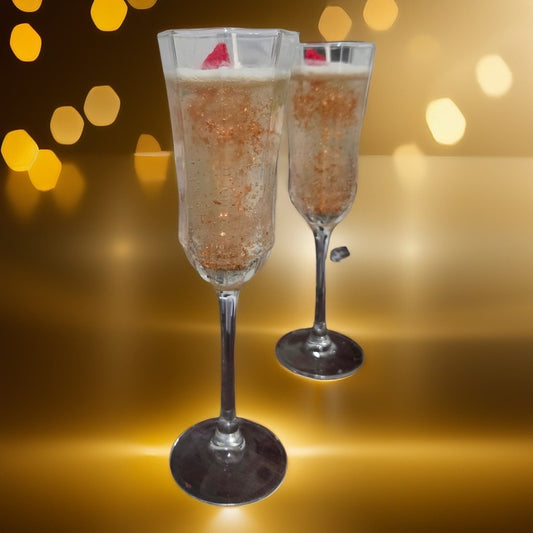 Deux chandelles gourmandes Champagne rosé dans leur flûte en verre.